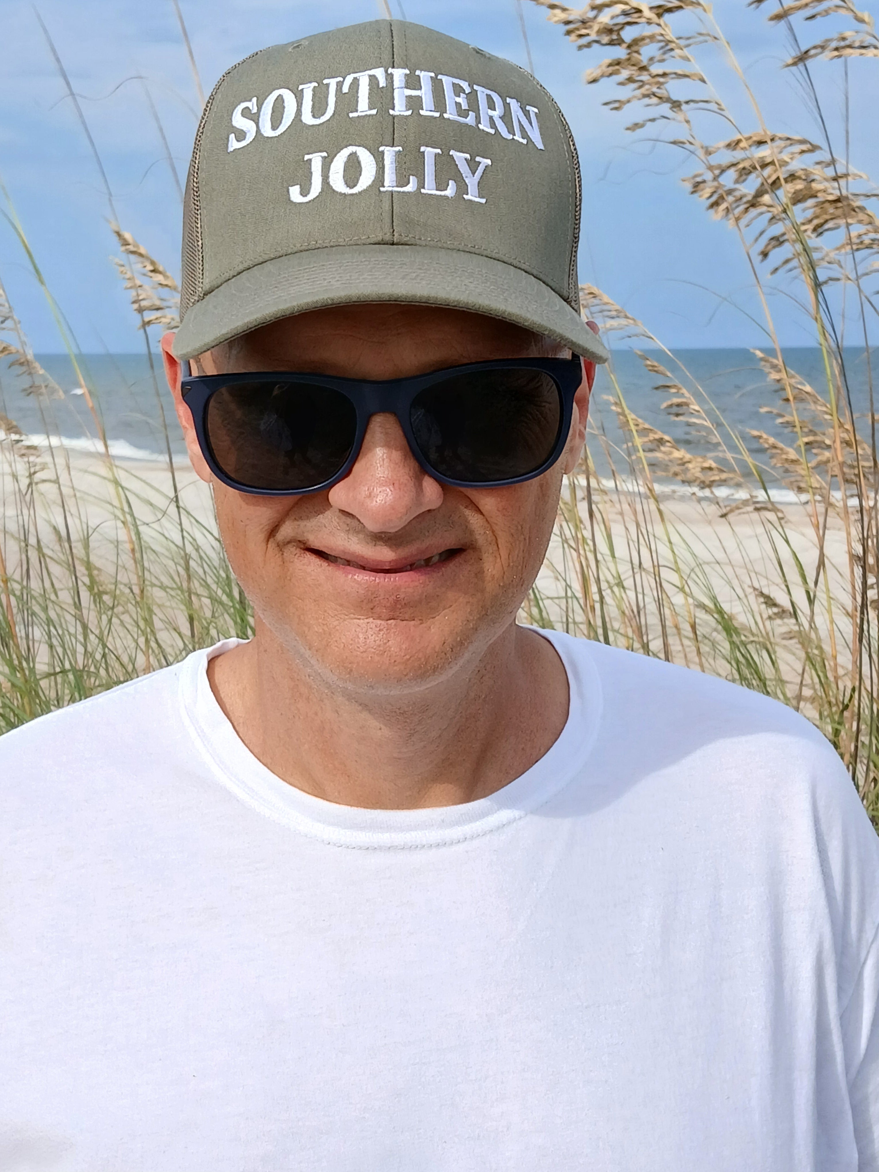 A man wearing a green trucker hat that says Southern Jolly.