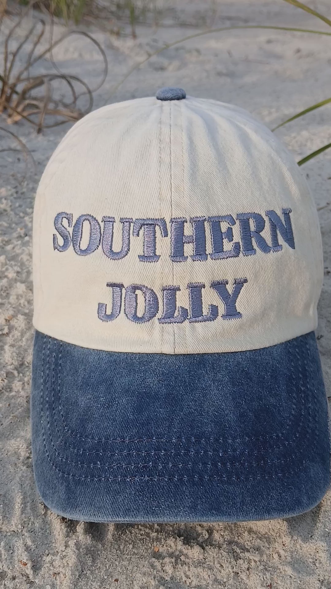 Video of Blue and Tan Ball Cap in the sand at the beach.
